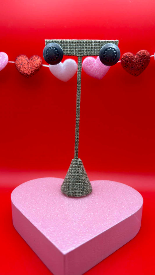 Jewelry stand with heart-shaped base and decorative hearts on a red background